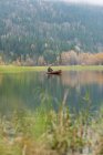 Чоловік веслує на каное в тихій річці в сонячний день — стокове фото