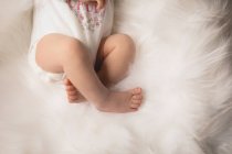 Vista recortada del bebé recién nacido acostado sobre una manta esponjosa . - foto de stock