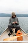 Чоловік у човні закріплює приманку до риболовлі — стокове фото