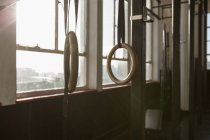 Anillos gimnásticos con correas en gimnasio por ventana . - foto de stock
