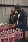 Travailleurs emballant des bouteilles de gin dans l'usine — Photo de stock