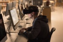 Хлопчик-підліток використовує гарнітуру віртуальної реальності під час навчання на комп'ютерному класі в університеті — стокове фото