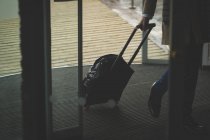 Бізнесмен прибуває в готель з сумкою на візку — стокове фото