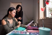 Créateurs de mode discutant sur des échantillons de tissu en studio . — Photo de stock