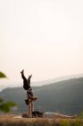 Casal desportivo praticando acro ioga em um terreno verde exuberante no momento do dwan — Fotografia de Stock