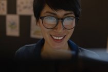 Крупним планом жінки-виконавця в окулярах, що працюють за допомогою комп'ютера в офісі . — стокове фото
