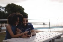 Paar nutzt Handy an sonnigem Tag auf Promenade — Stockfoto