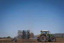 Traktor streut an sonnigem Tag Dünger auf Feld — Stockfoto
