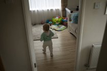 Rückansicht eines kleinen Mädchens, das zu Hause rennt — Stockfoto