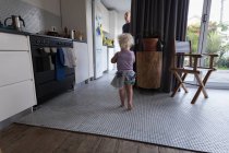 Toddler girl walking in kitchen at home. — Stock Photo