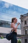 Молода спортивна жінка розмовляє по мобільному телефону на вулиці — стокове фото