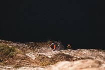 Решительная пара путешественников, взбирающаяся на скалистую гору — стоковое фото