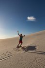 Mann Sandboarding auf Sanddüne an einem sonnigen Tag — Stockfoto