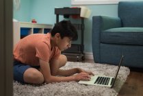 Уважний хлопчик використовує ноутбук вдома — стокове фото