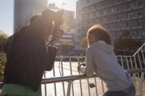 Fotograf, der an einem sonnigen Tag ein Modell auf der Straße fotografiert — Stockfoto