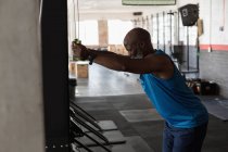 Determined senior man working out in fitness studio. — Stock Photo