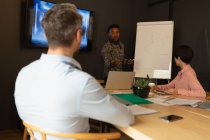 Empresários discutindo sobre quadro branco na sala de reuniões no escritório . — Fotografia de Stock