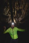 Primer plano del excursionista explorando la cueva oscura - foto de stock