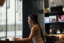 Бізнес-леді сидить наодинці з кавою в кафетерії — стокове фото