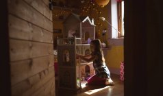 Menina brincando com casa de bonecas no quarto em casa — Fotografia de Stock