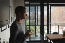 Вдумчивый молодой человек пьет кофе дома — стоковое фото