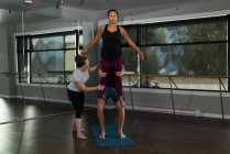Fit people practicing acroyoga in fitness studio. — Stock Photo