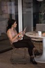 Femme cadre de bureau utilisant tablette numérique à la cafétéria au bureau créatif — Photo de stock
