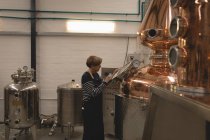 Macchina di controllo operaia femminile della distilleria in fabbrica — Foto stock