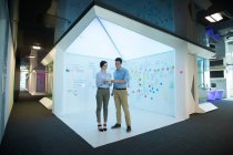 Männliche und weibliche Führungskräfte nutzen digitales Tablet im futuristischen Büro — Stockfoto