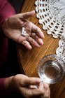 Visão de alto ângulo de mãos de mulher sênior que toma medicamentos — Fotografia de Stock
