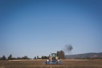 Tractor plowing the field on a sunny day — Stock Photo