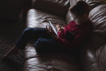 Хлопчик використовує цифровий планшет у вітальні вдома — стокове фото
