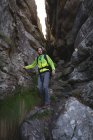 Primo piano dell'escursionista che scende su rocce con lo zaino — Foto stock