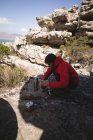 Caminhante preparando bebida durante pausa na montanha — Fotografia de Stock