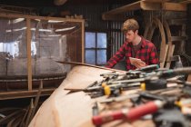 Young male carpenter using digital tablet in workshop — Stock Photo