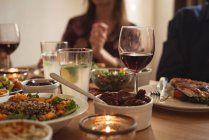 Seção intermediária de amigos que comem à mesa — Fotografia de Stock