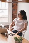 Thoughtful female executive sitting on chair in the creative office — Stock Photo