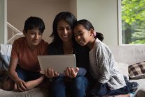Mãe e filhos tendo videochamada no laptop na sala de estar em casa — Fotografia de Stock