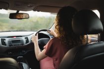 Visão traseira da mulher dirigindo um carro — Fotografia de Stock