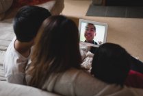 Мати і діти мають відеодзвінок на ноутбук у вітальні вдома — стокове фото