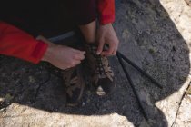 Крупный план туриста, завязывающего шнурки в солнечный день — стоковое фото