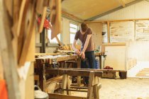 Junge Tischlerin arbeitet in Werkstatt — Stockfoto