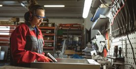 Жінка-працівник ремонтує машину з інструментом на заводі — стокове фото