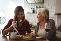 Senior mulher e filha comendo omelete e vinho no café da manhã — Fotografia de Stock