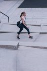 Giovane donna sportiva che cammina per strada — Foto stock