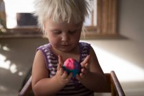Toddler girl playing with colorful clay, close-up. — Stock Photo