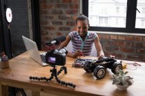 Vorpubertäre Bloggerin lötet Leiterplatte von Elektro-Spielzeugauto im Büro. — Stockfoto