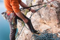 Low section of rock climber climbing the rocky mountain — Stock Photo
