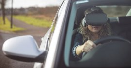 Красива жінка-виконавця з використанням гарнітури віртуальної реальності під час водіння автомобіля — стокове фото