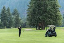 Golfeur frapper un tir de golf dans le parcours — Photo de stock